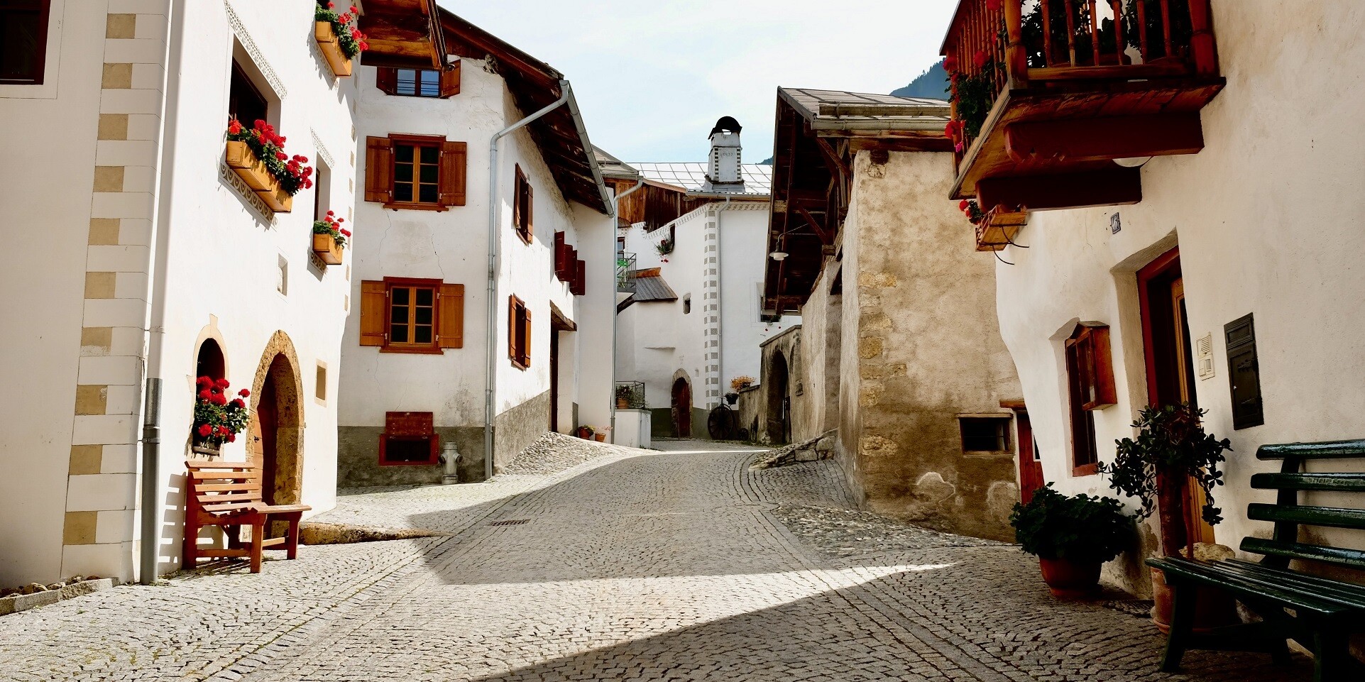 A steep path with cobble stones between the typical Engadin homes.
