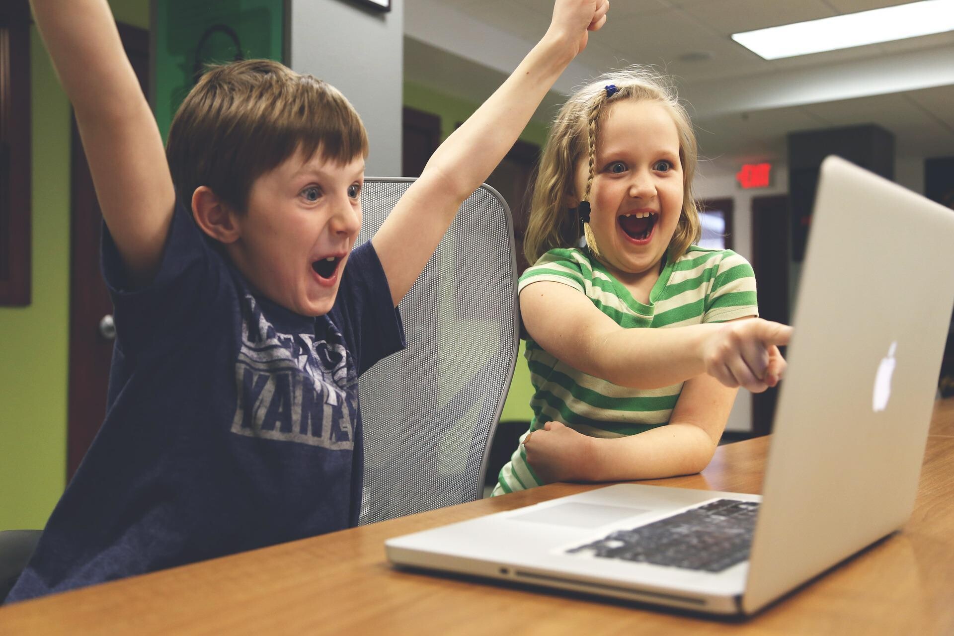 junge und mädchen freuen sich vor computer