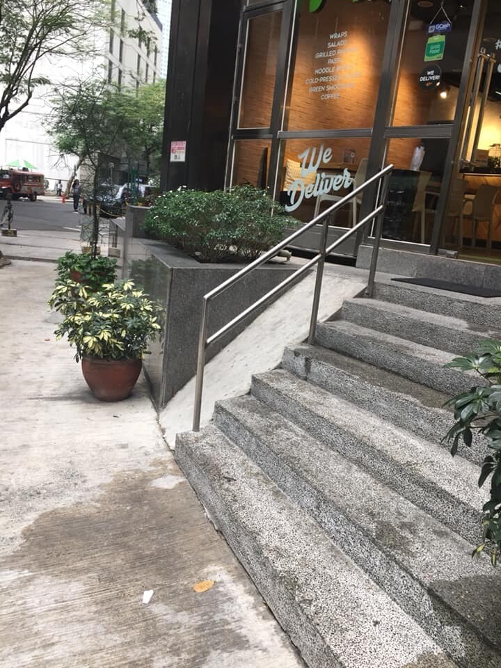 Beside the stairs in front of a restaurant, the ramp is at around a 45-degree angle.