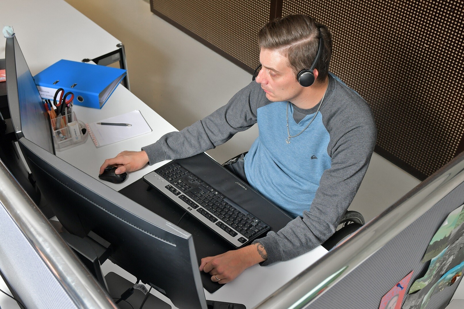 Florian Bickel siede alla sua postazione di lavoro davanti al computer.
